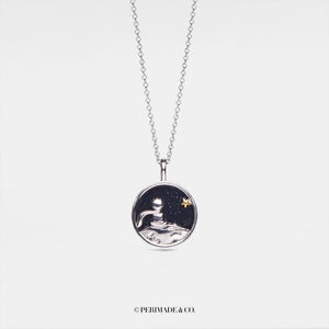 Necklace with a round pendant featuring a night sky design on a white background.