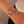 Silver bracelet with moon, heart, and star charms on a wrist against a neutral background