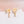 Pair of gold earrings with floral and pearl designs on a white surface.