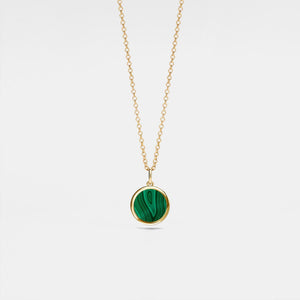 Gold locket necklace with a green malachite pendant on a light gray background