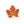 Decorative leaf brooch with orange and gold colors on a white background