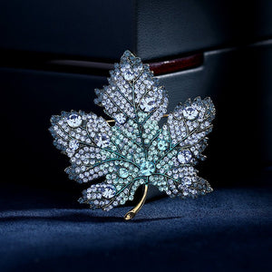 Diamante maple leaf brooch on a dark background