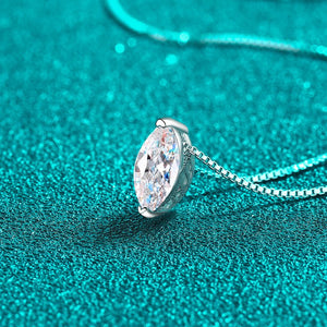 Silver necklace with a teardrop-shaped diamond pendant on a teal background
