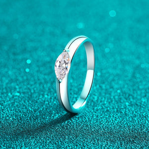 Silver ring with a diamond on a teal textured background