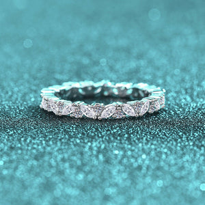 Silver ring with gemstones on a teal glittery background