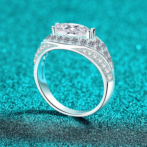 Silver ring with a large moissanite on a turquoise glittery background