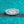 Teardrop-shaped moissanite ring with a turquoise glittery background