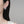 Star-shaped silver earring worn by a person on a plain background