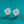 Pair of silver flower-shaped earrings on a teal background
