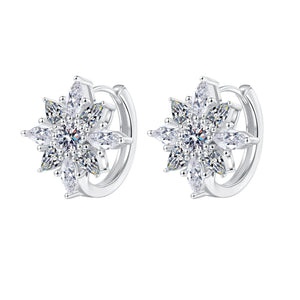 Pair of silver earrings with star-shaped clear gemstones on a white background