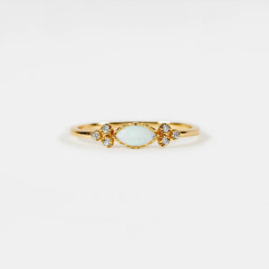 Gold ring with a light blue gemstone on a white background