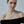 Woman wearing a gold necklace against a plain background
