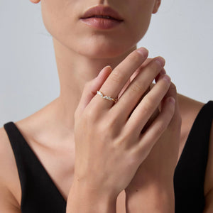 Close-up of a woman's hand wearing a ring with a neutral background