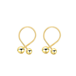 Pair of gold hoop earrings with spherical ends on a white background