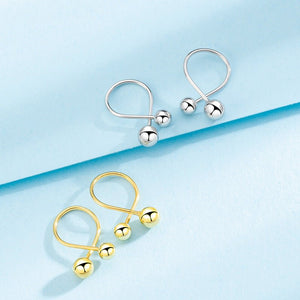 Gold and silver earrings on a light blue background