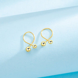 Gold earrings on a light blue background