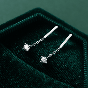 Silver earrings with gemstones on a green velvet surface