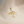 Gold snake-shaped ring on a beige fabric background