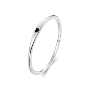 Silver ring with a small black heart on a white background