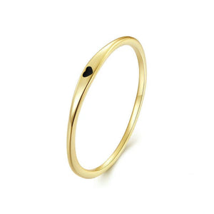 Gold ring with a small black heart on a white background