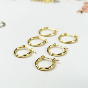 Set of gold hoop earrings on a light background