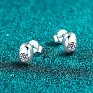 Silver earrings with gemstones on a teal glittery background