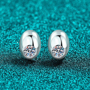 Silver earrings with gemstones on a teal textured background