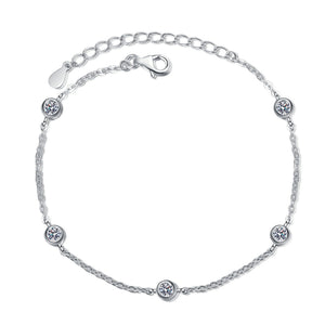 Silver bracelet with small round moissanite on a white background