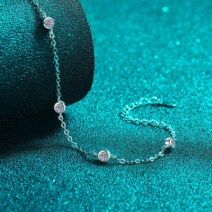 Silver bracelet with gemstones on a teal textured surface