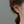 Close-up of an ear wearing gold hoop earrings with a neutral background