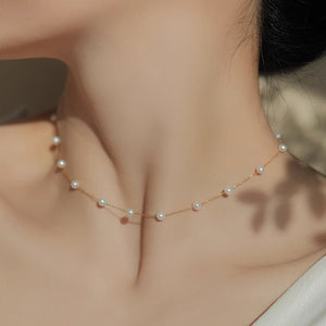 Pearl necklace on a person's neck with a neutral background