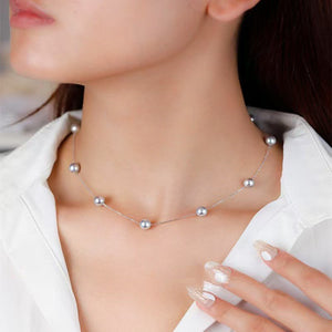 Pearl necklace worn by a model with a blurred background