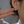 Gold earrings with clear gemstones worn by a person, held up to the ear.