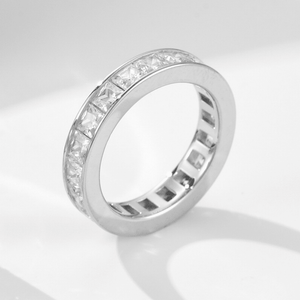 Silver ring with diamond accents on a light gray background