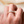 Gold ring with diamonds on a person's finger against a neutral background