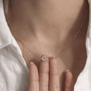 Silver necklace with a unique clasp worn by a person