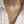 Gold necklace with a pendant on a person wearing a white shirt.