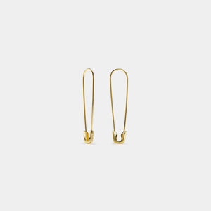 Gold safety pin earrings on a light gray background