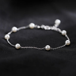 Silver bracelet with pearls on a black background