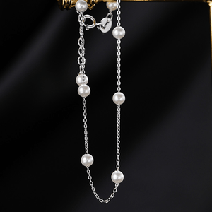 Pearl necklace with silver chain on a dark background
