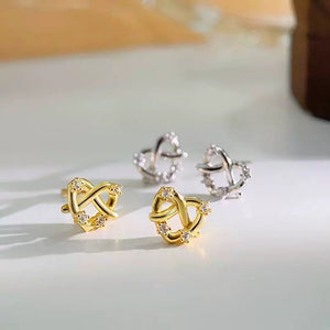 Gold and silver earrings on a light surface