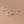 Three hoop earrings in silver and rose gold on a beige background