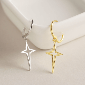Gold and silver star-shaped earrings on a light background