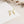 Gold star-shaped earrings on a white card with a beige background