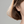 Close-up of a person wearing gold earrings with a neutral background