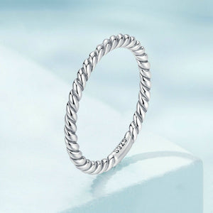 Silver twisted ring on a light blue background