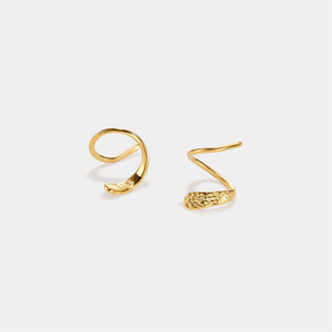Gold ear cuff and earrings on a light gray background