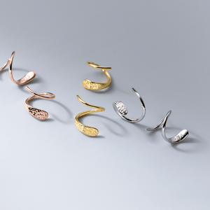 Set of gold and silver ear cuffs on a gray background