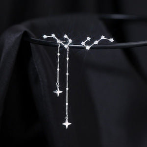 Silver star-shaped earrings on a black background