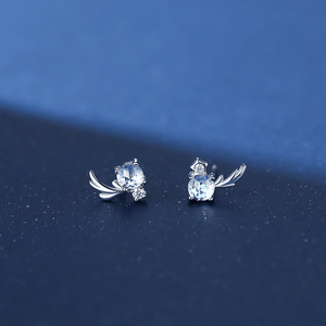 Pair of silver earrings with gemstones on a blue background
